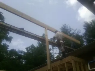 Carpenter setting a ridge beam over a new addition frame — Ice Dam Removal by Roofing Brothers in Vantage