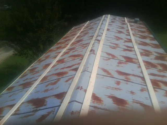 Rusted metal roof panels with new wood purlins before replacement — Storm Damage Roof Repair in Vantage by Roofing Brothers