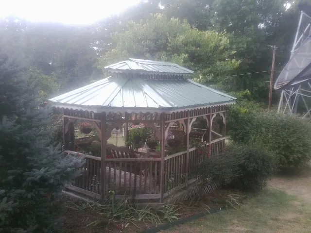 Green metal roof on a backyard gazebo surrounded by garden beds in Vantage