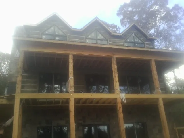 Dormers and porch framing on a large log home under construction — Roof Coating work by our crew in Vantage