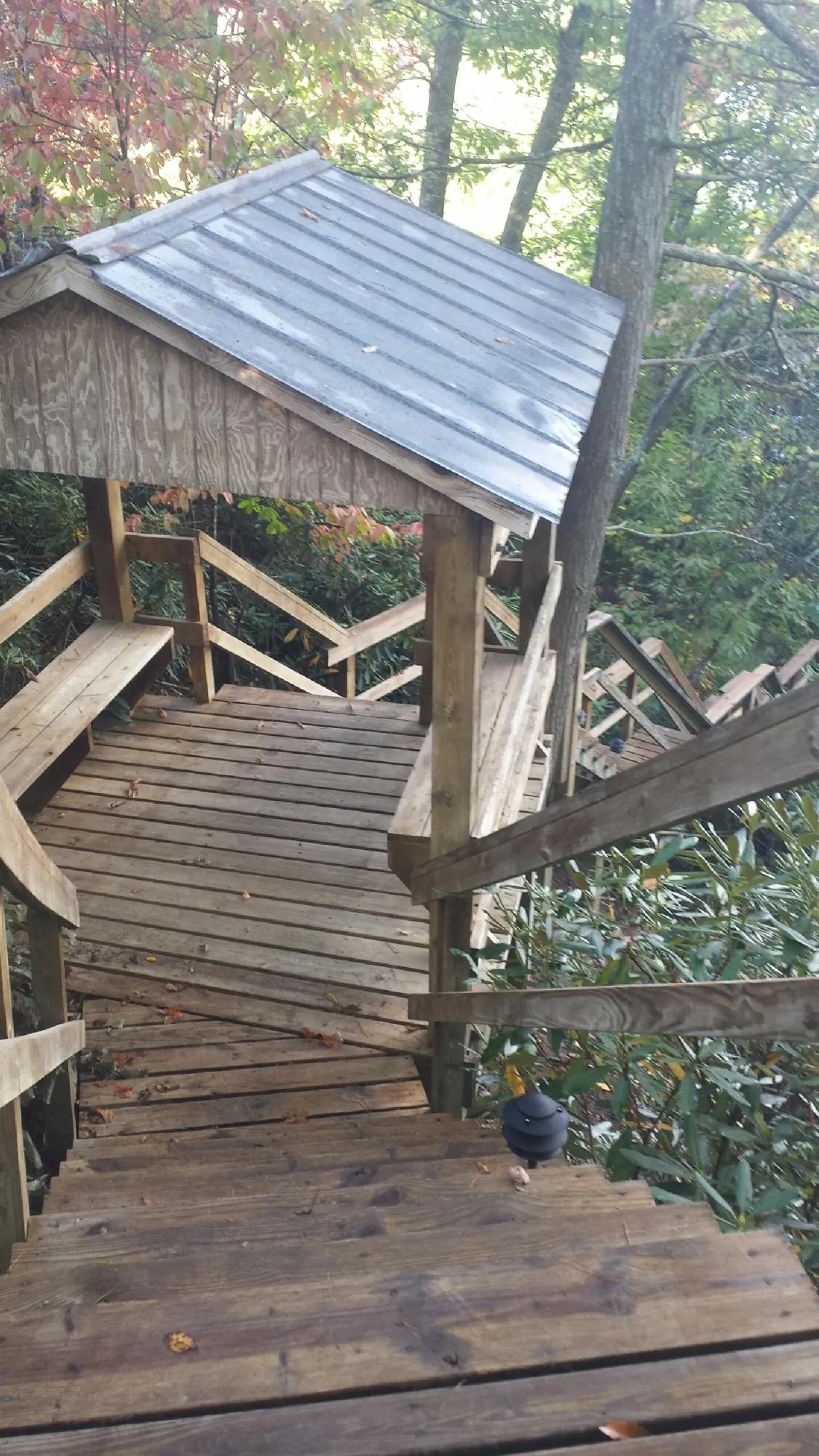 Metal roofed shelter over wooden steps on a wooded walkway — Skylight Repair & Installation work by our crew in Vantage